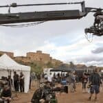 Film crew working on a historical set in Morocco, capturing a bustling market scene with elaborate set design and period costumes