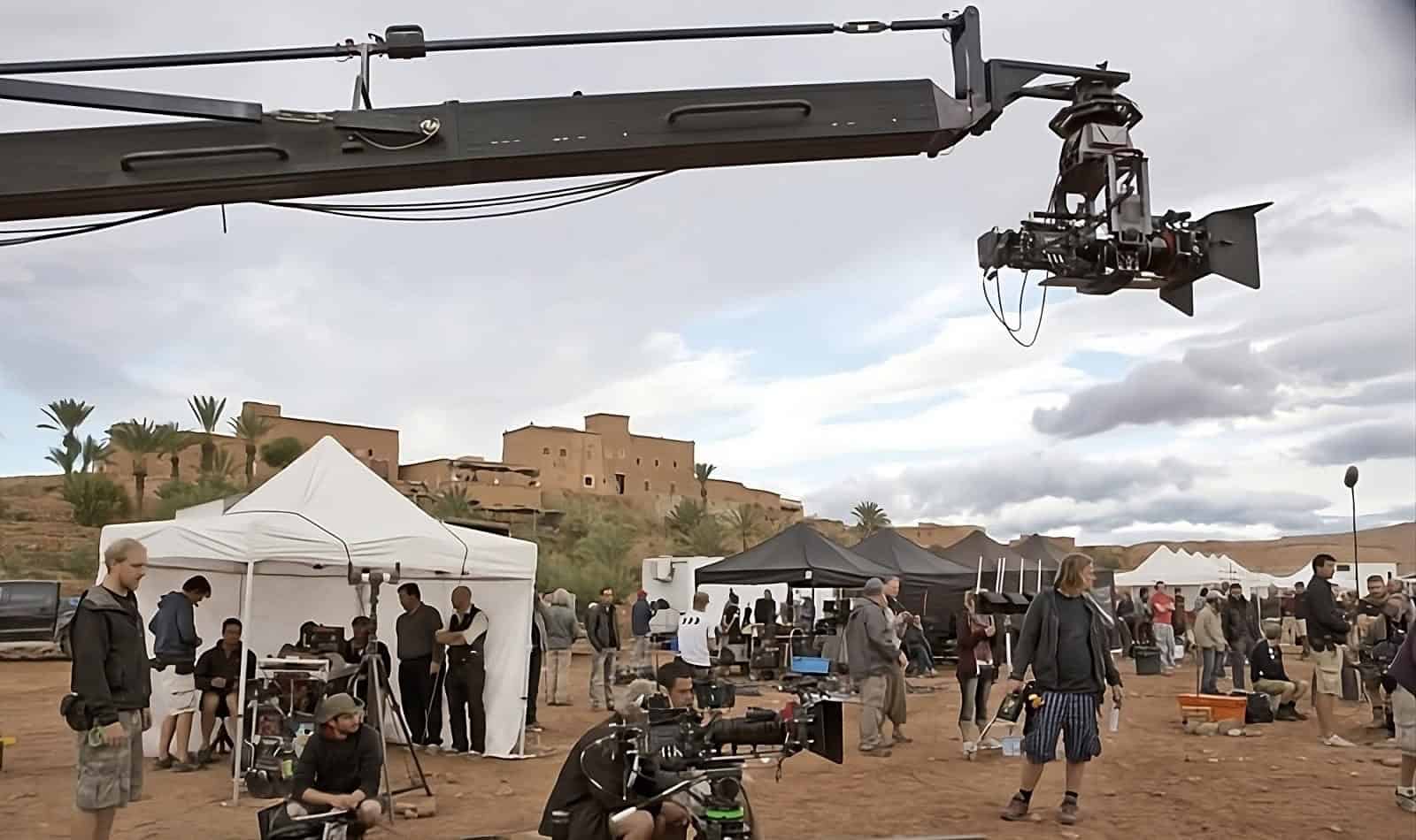 Film crew working on a historical set in Morocco, capturing a bustling market scene with elaborate set design and period costumes